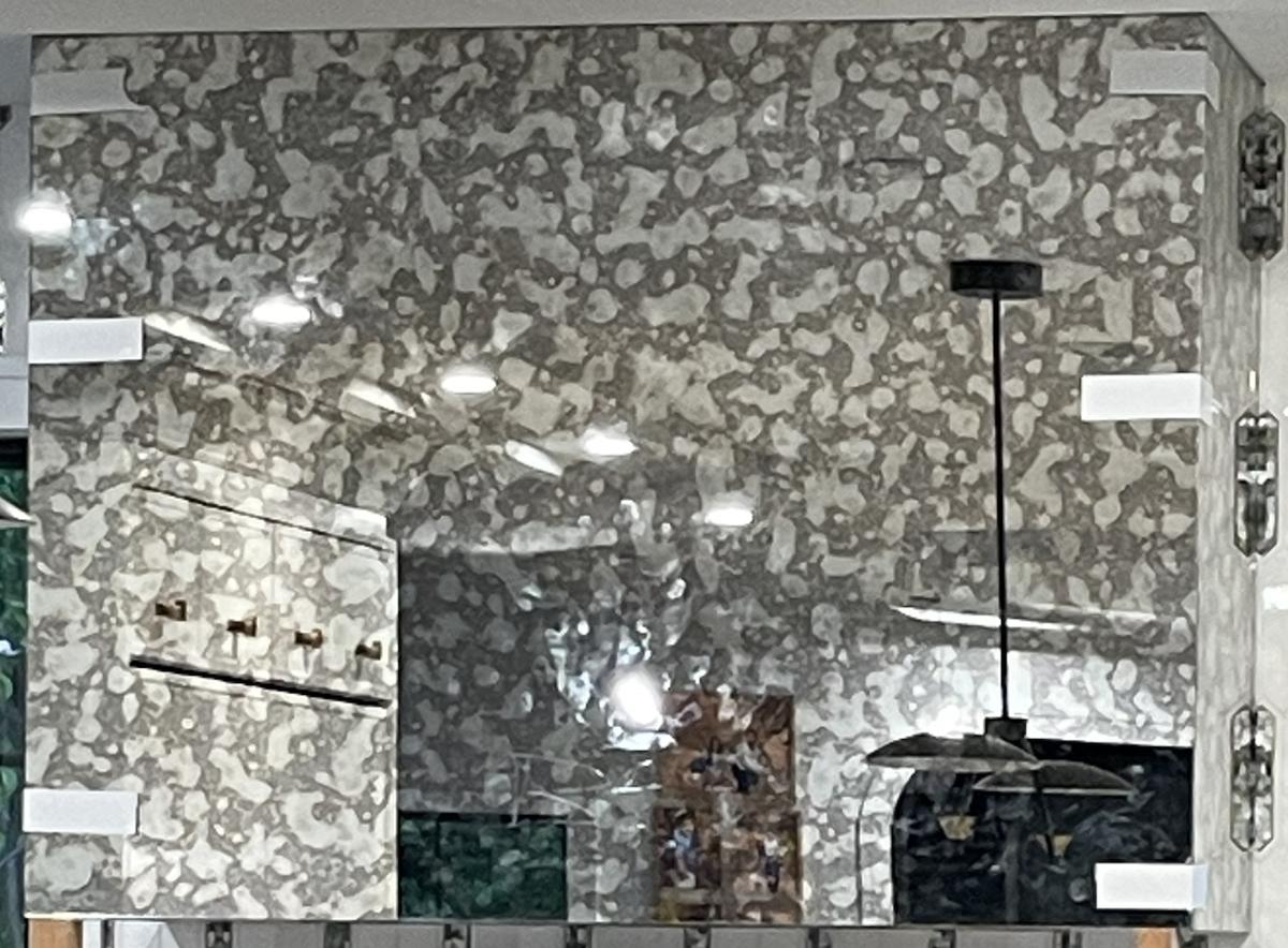 Antique mirror cladding on a kitchen range hood