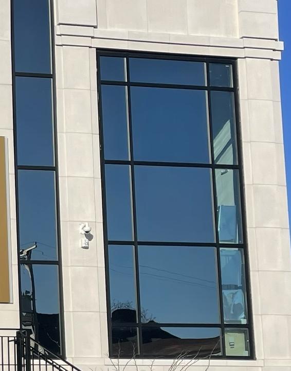 Black-frame window walls on a new limestone building