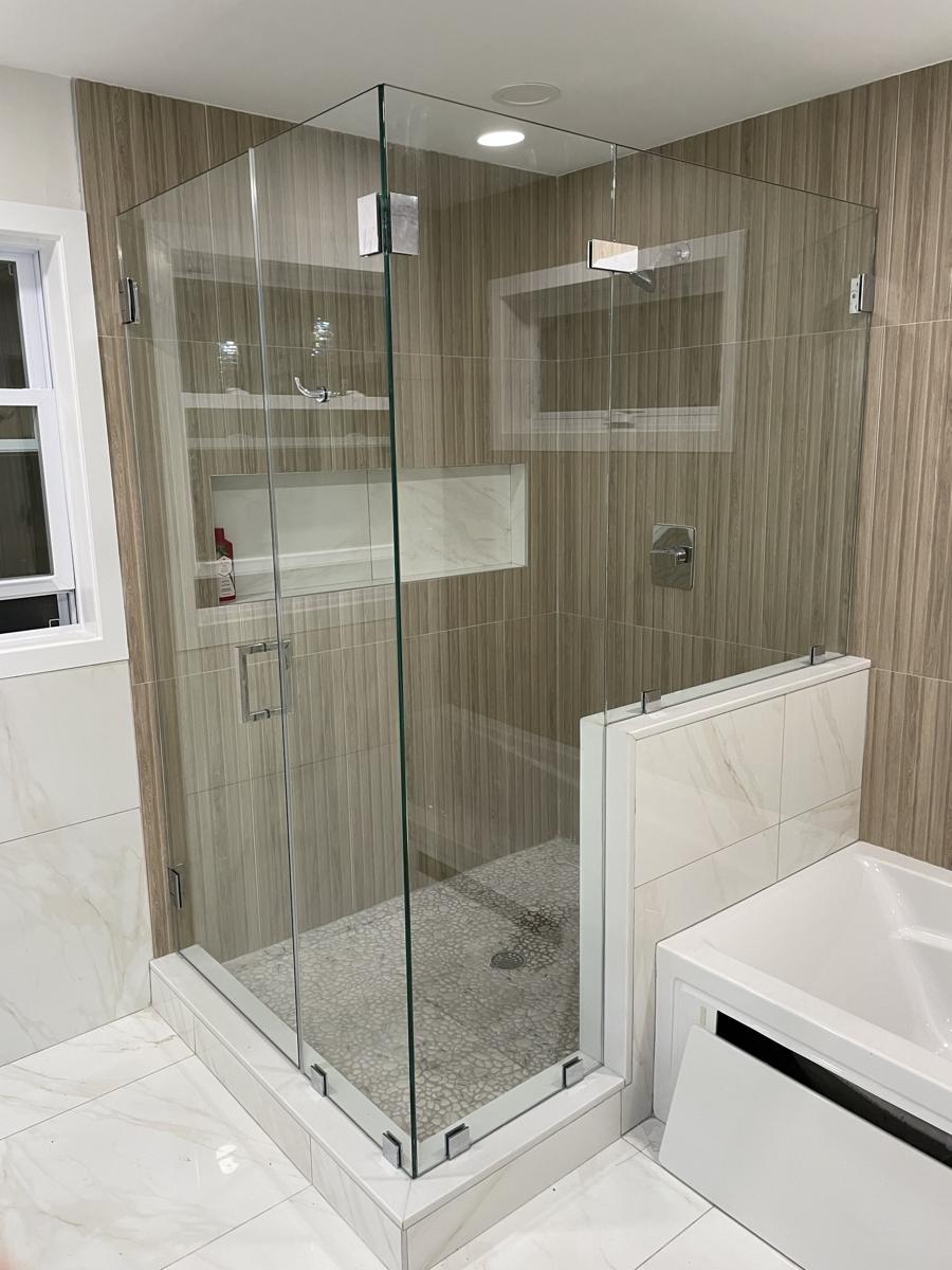 Corner frameless shower with chrome clamps and pebble floor