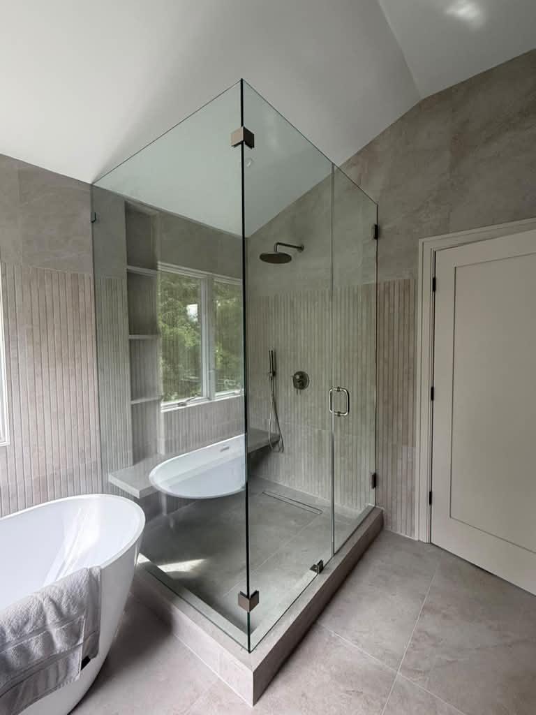 Corner frameless shower under a vaulted ceiling