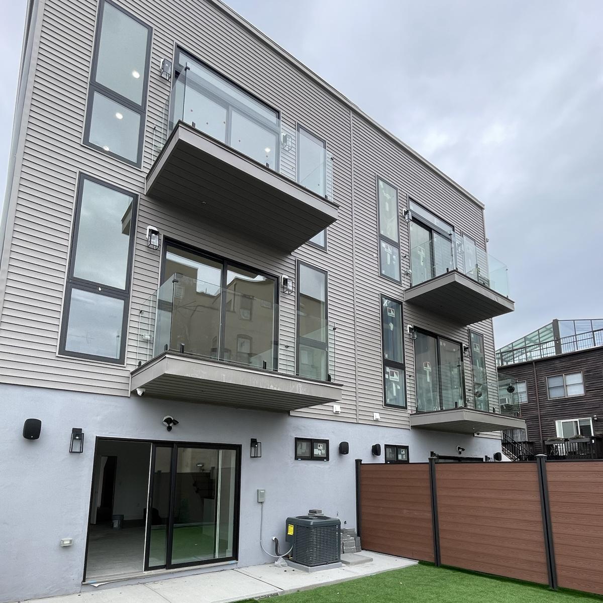 Exterior frameless glass balcony railings on new townhomes