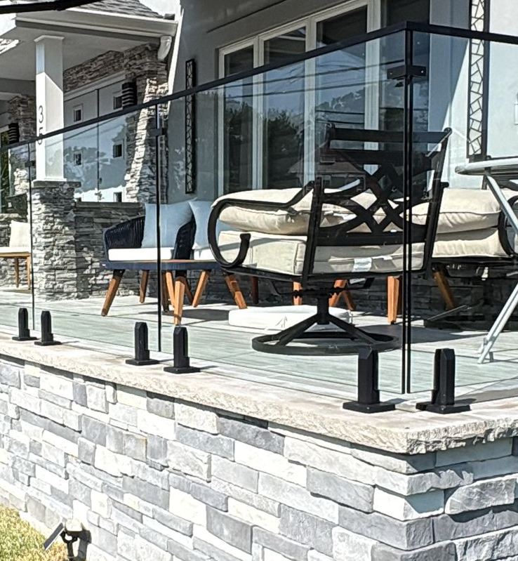 Exterior frameless glass patio railing with black spigots