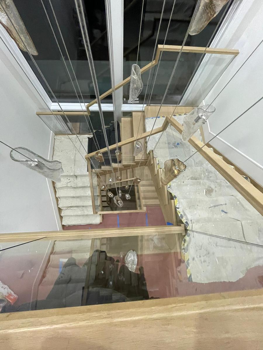 Floor-to-ceiling glass stair enclosure in an open-plan home