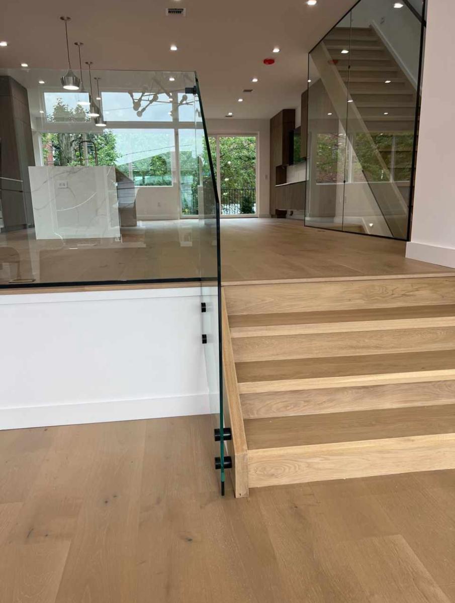 Frameless glass guard and floor-to-ceiling stair enclosure in a split-level home