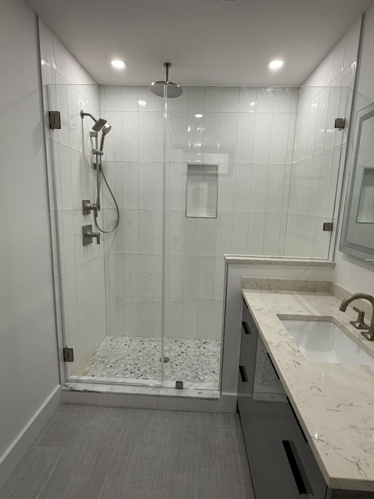 Frameless shower door and panel with brushed nickel hinges