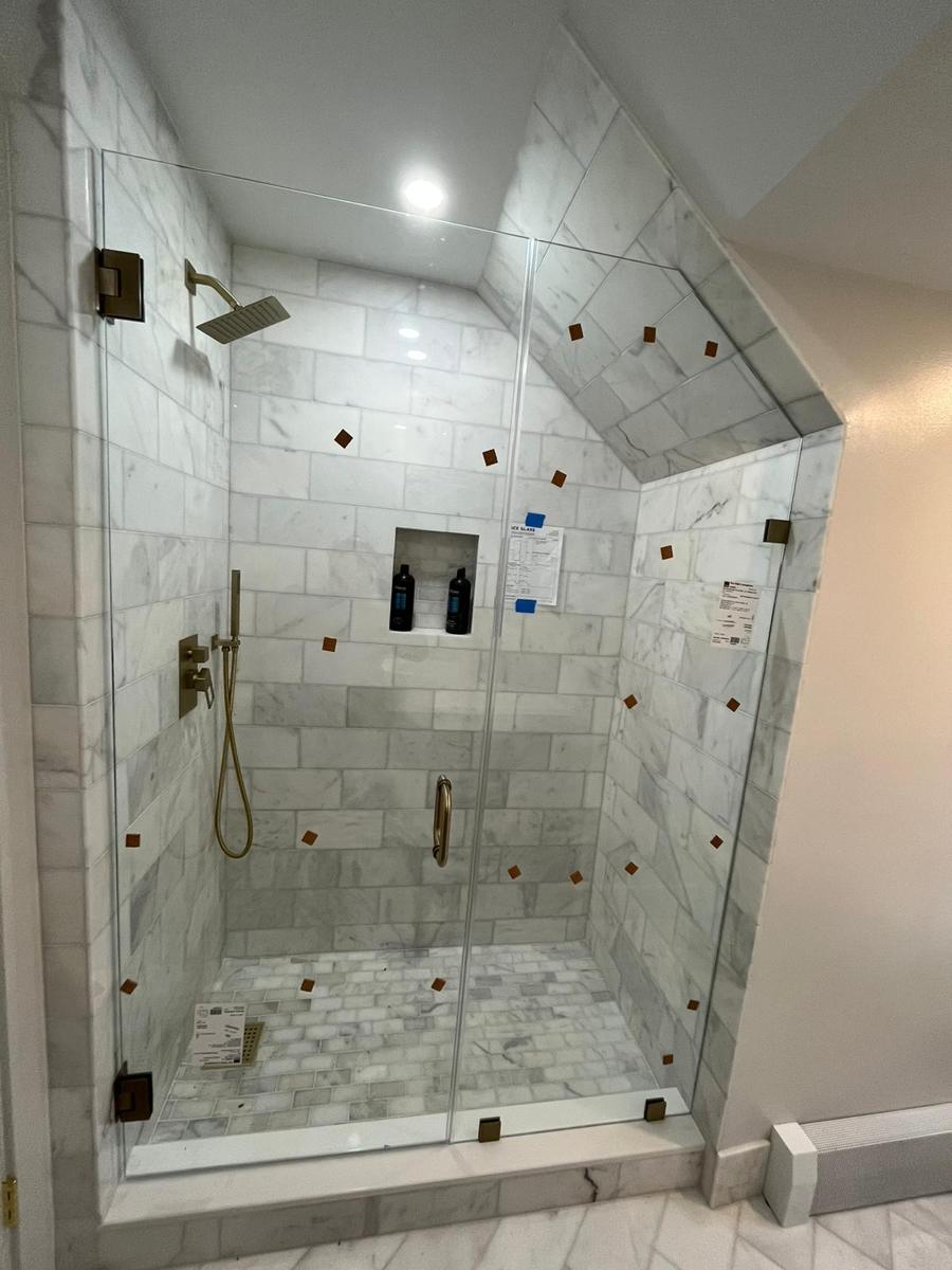 Frameless shower cut to a sloped attic ceiling