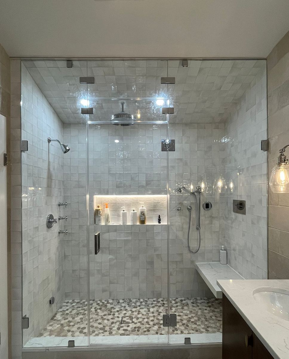Floor-to-ceiling steam shower with transom, chrome hardware and pebble floor