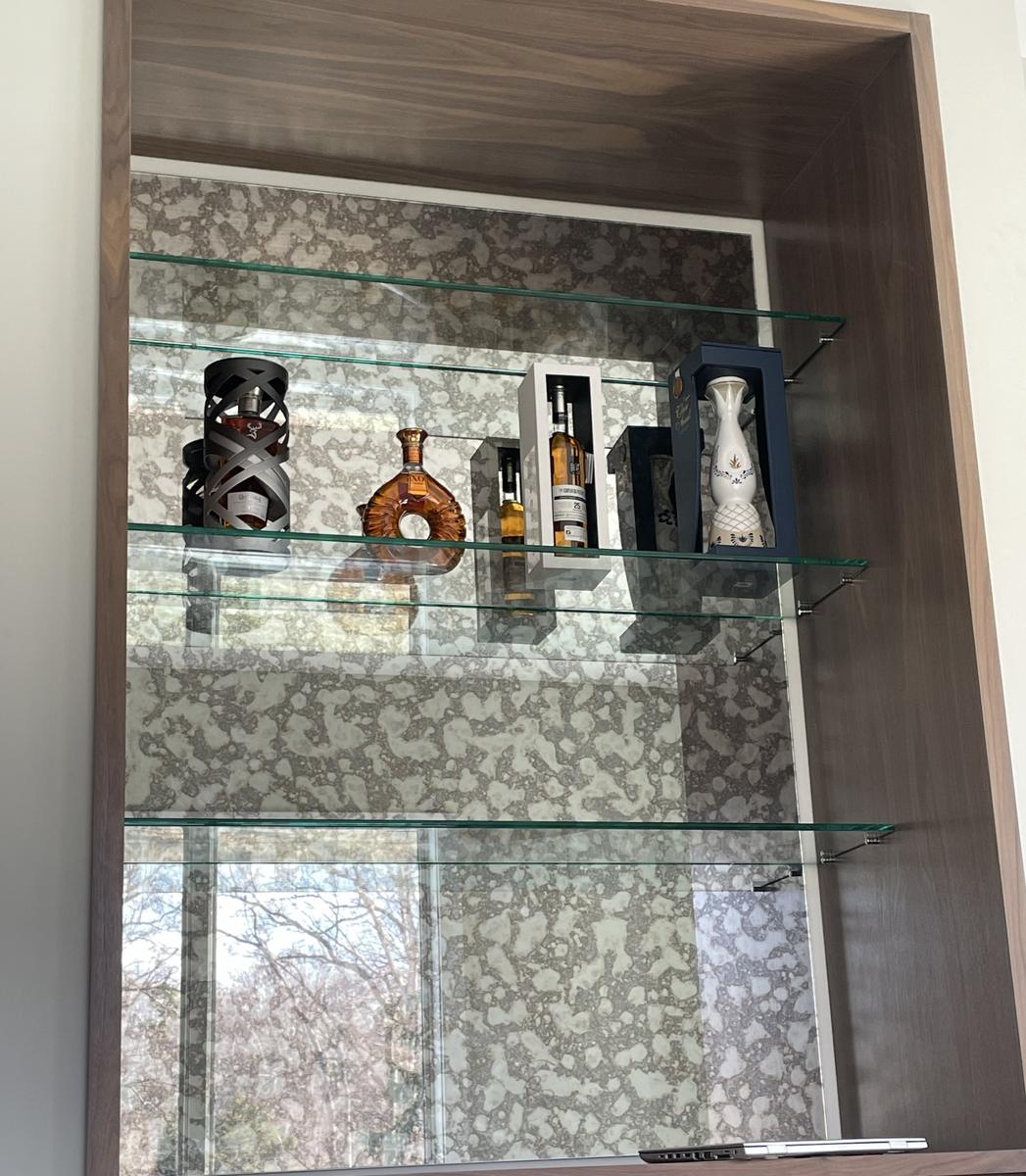 Floating glass bar shelves with an antique mirror back