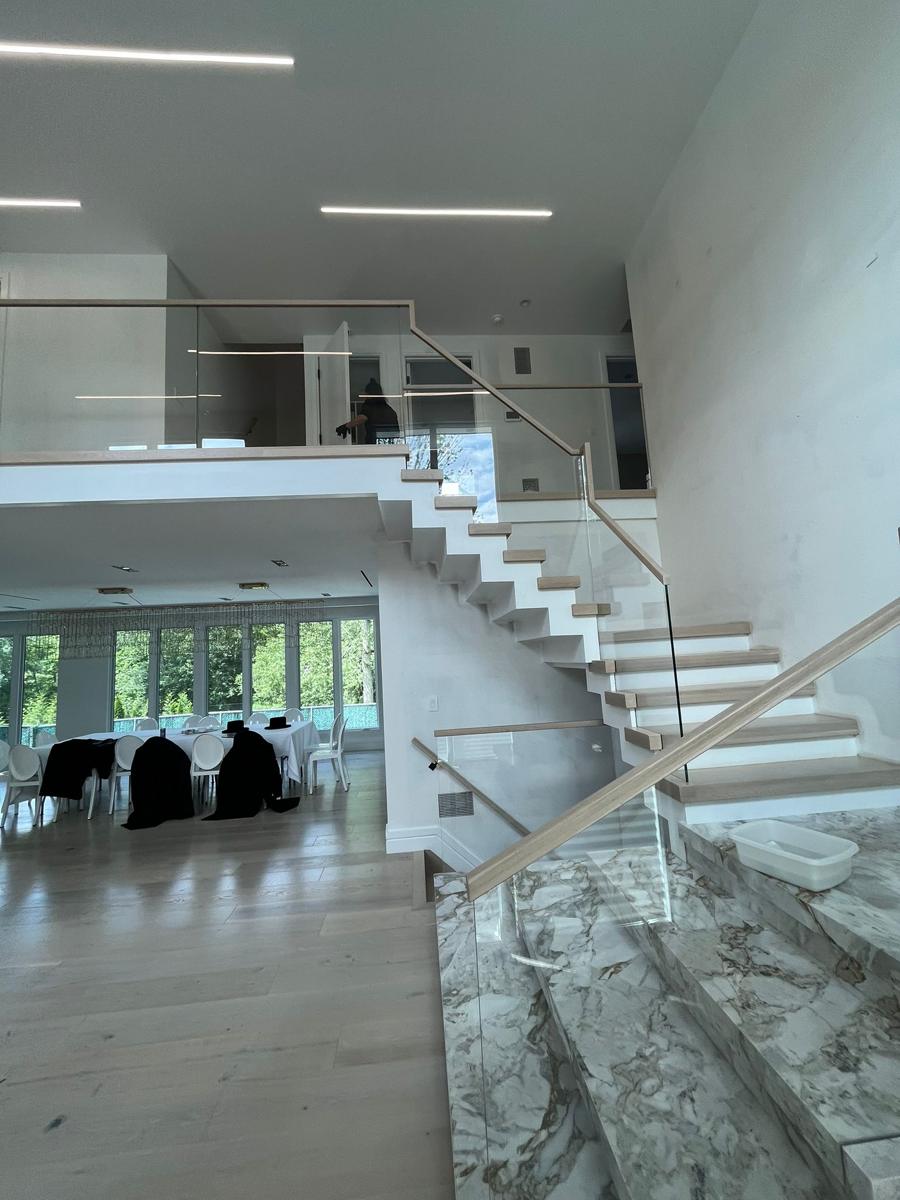 Glass loft and stair railing with oak handrail