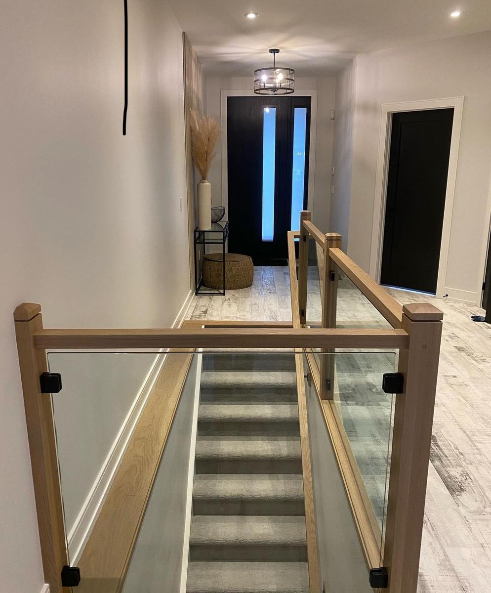 Glass railing with oak posts around a stairwell
