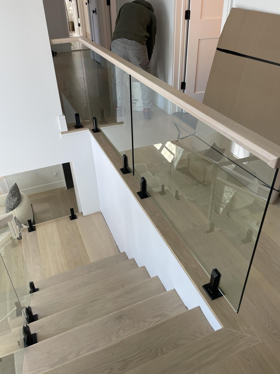 Glass landing railing with wood cap