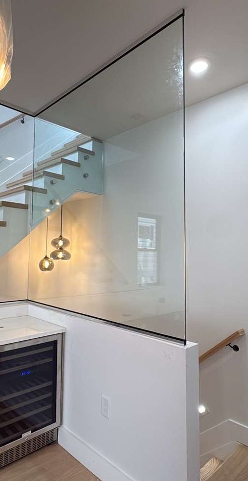 Floor-to-ceiling glass stair guard wall beside a wine bar