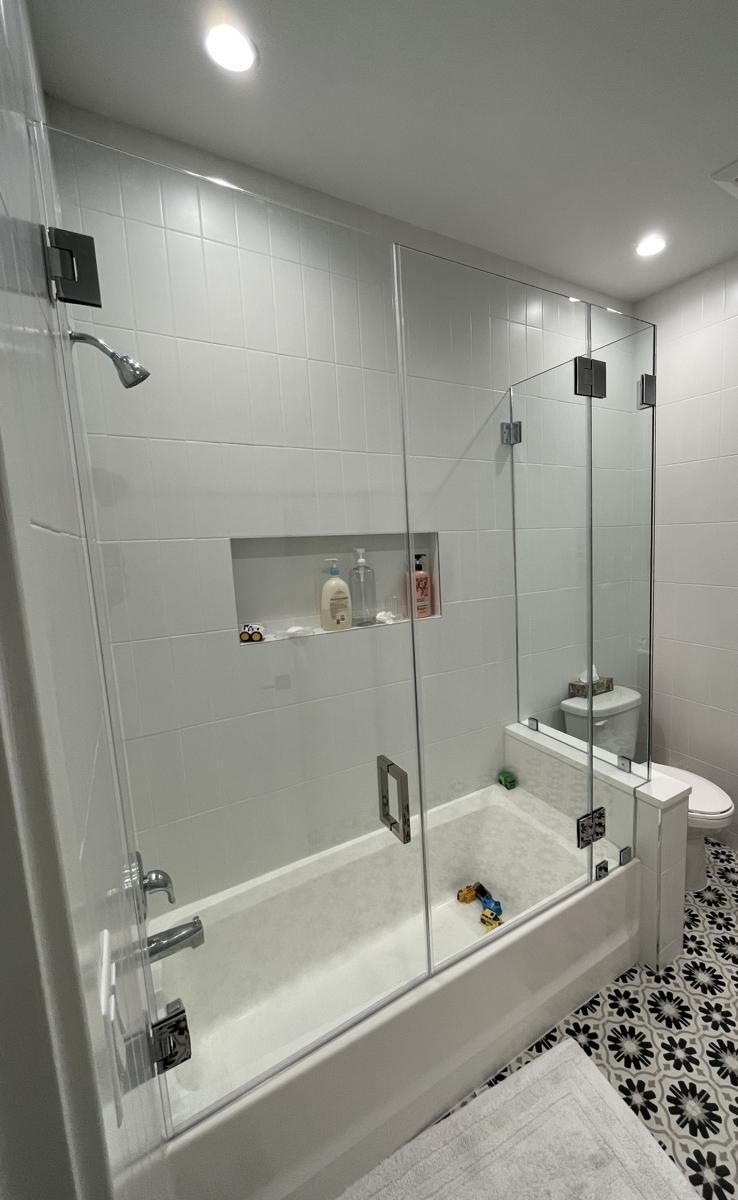 Hinged frameless tub enclosure over a knee wall, chrome