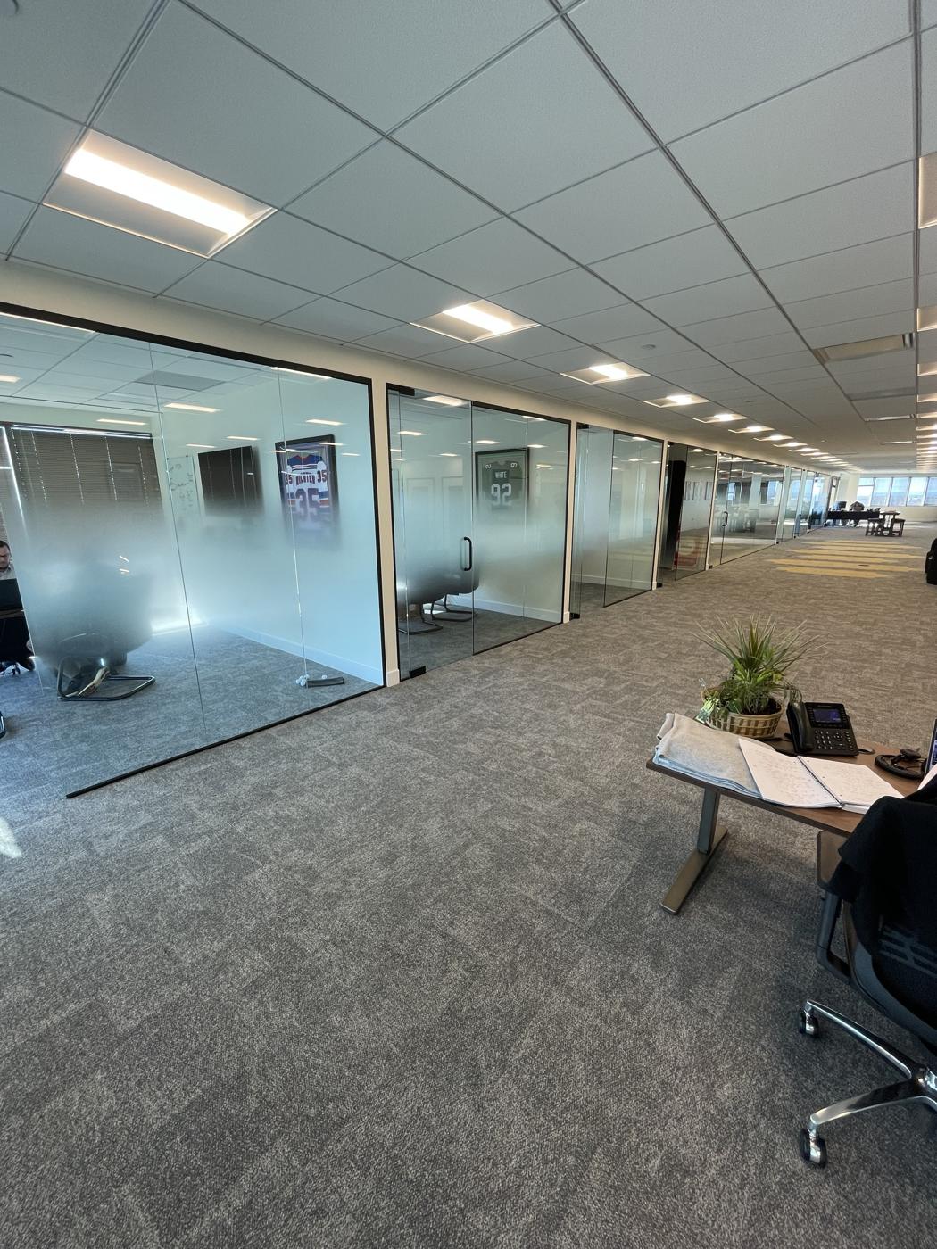 Row of frameless glass office fronts with frosted film